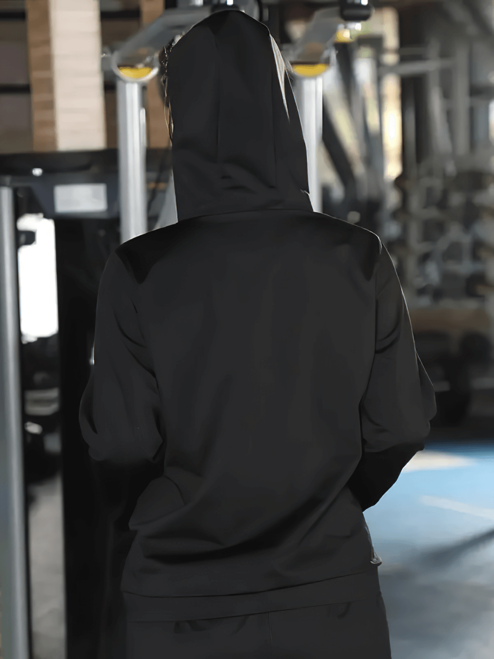 Woman in gym wearing black hooded tracksuit SF2247, designed for sweating and fitness. Ideal for workouts and weight loss.